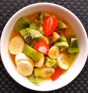 Soupe de fruits frais pour le goûter (jus d'orange, citron vert et passion pressée, banane, kiwi, fraise.